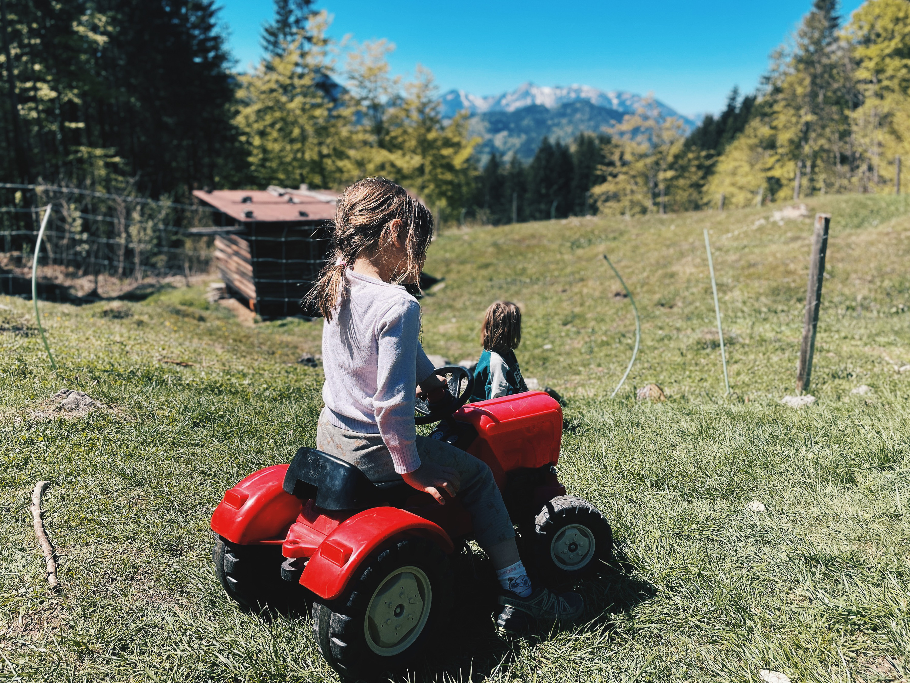 Kind auf einem kleinen Traktor bei der Feldlahnalm