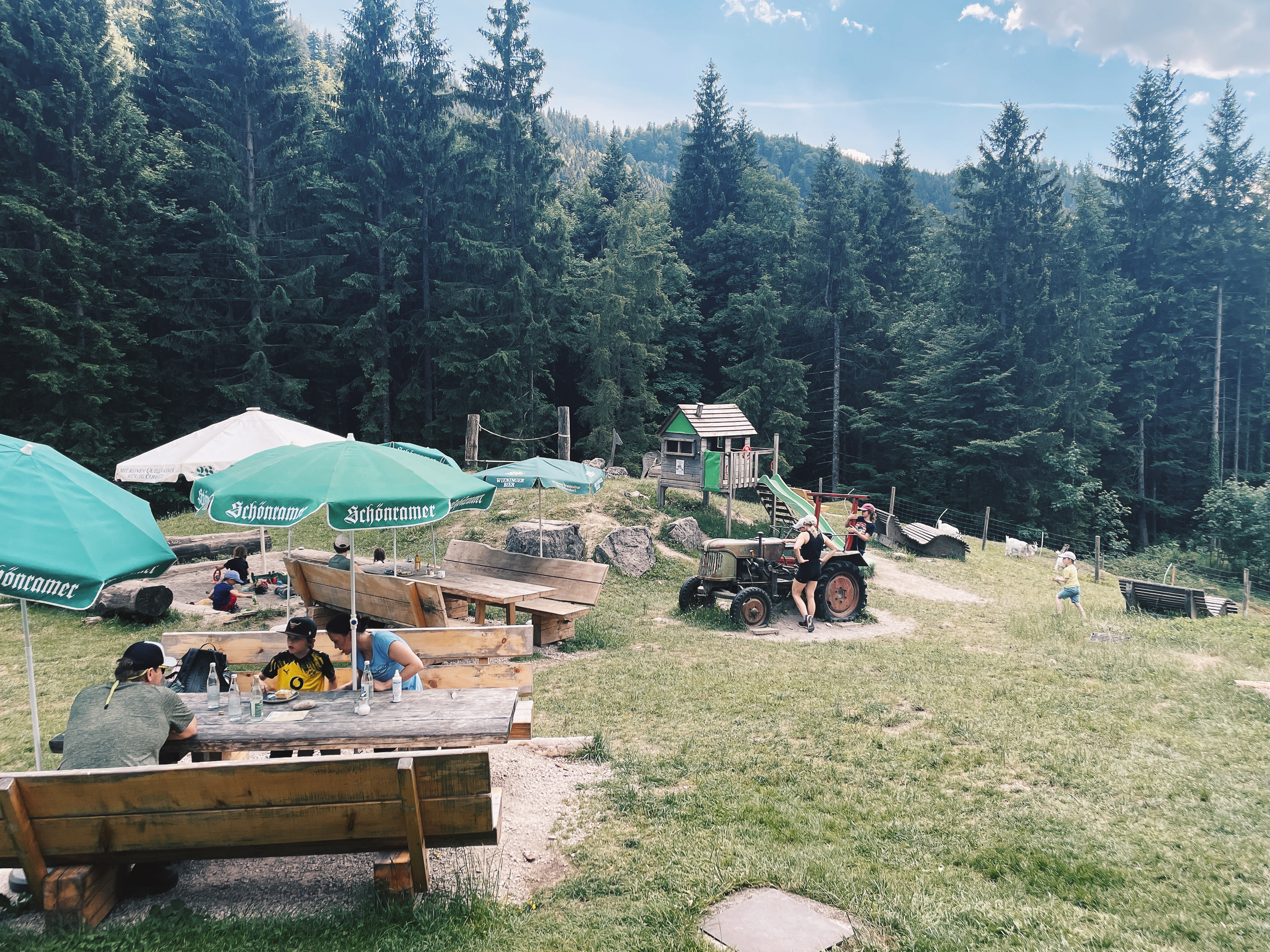 Terrasse der Feldlahnalm mit Sitzplätzen, Spielplatz und Traktor in Oberwössen