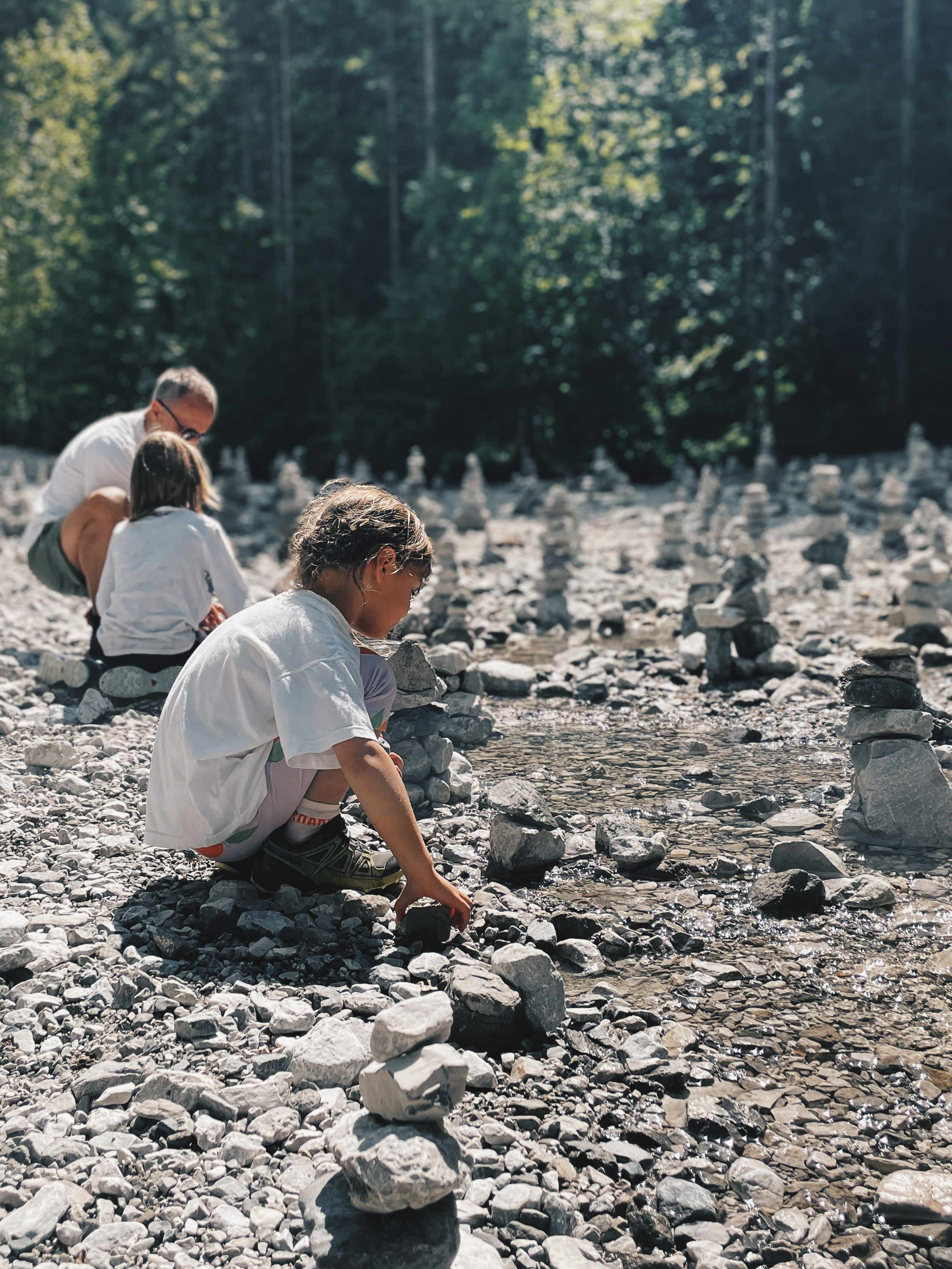 Kinder beim Spielen und Bauen mit Steinen am Bach der Grießbachklamm