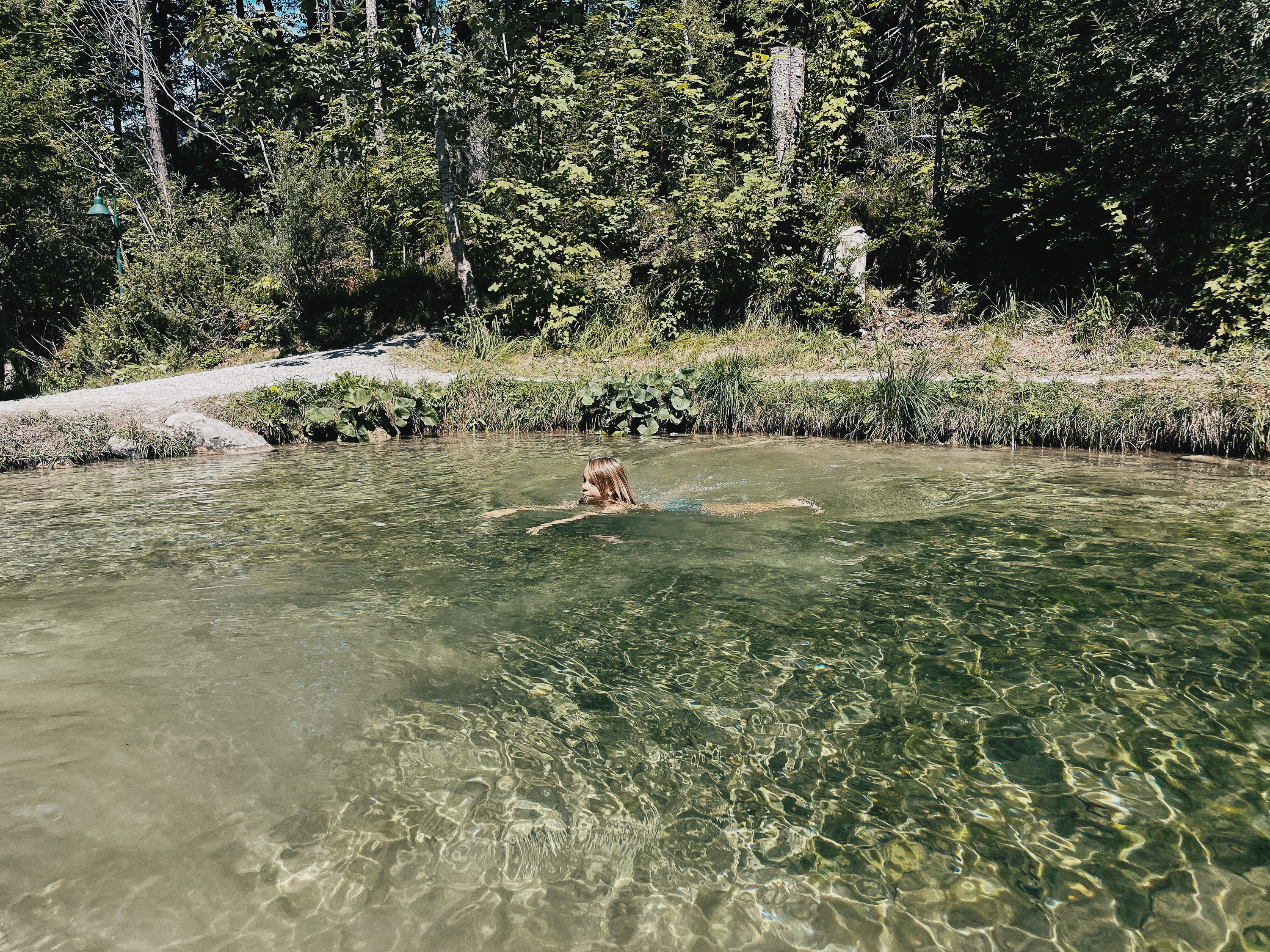 Ein Junge schwimmt in den kleinen Stausee in der Natur bei der Grießbachklamm