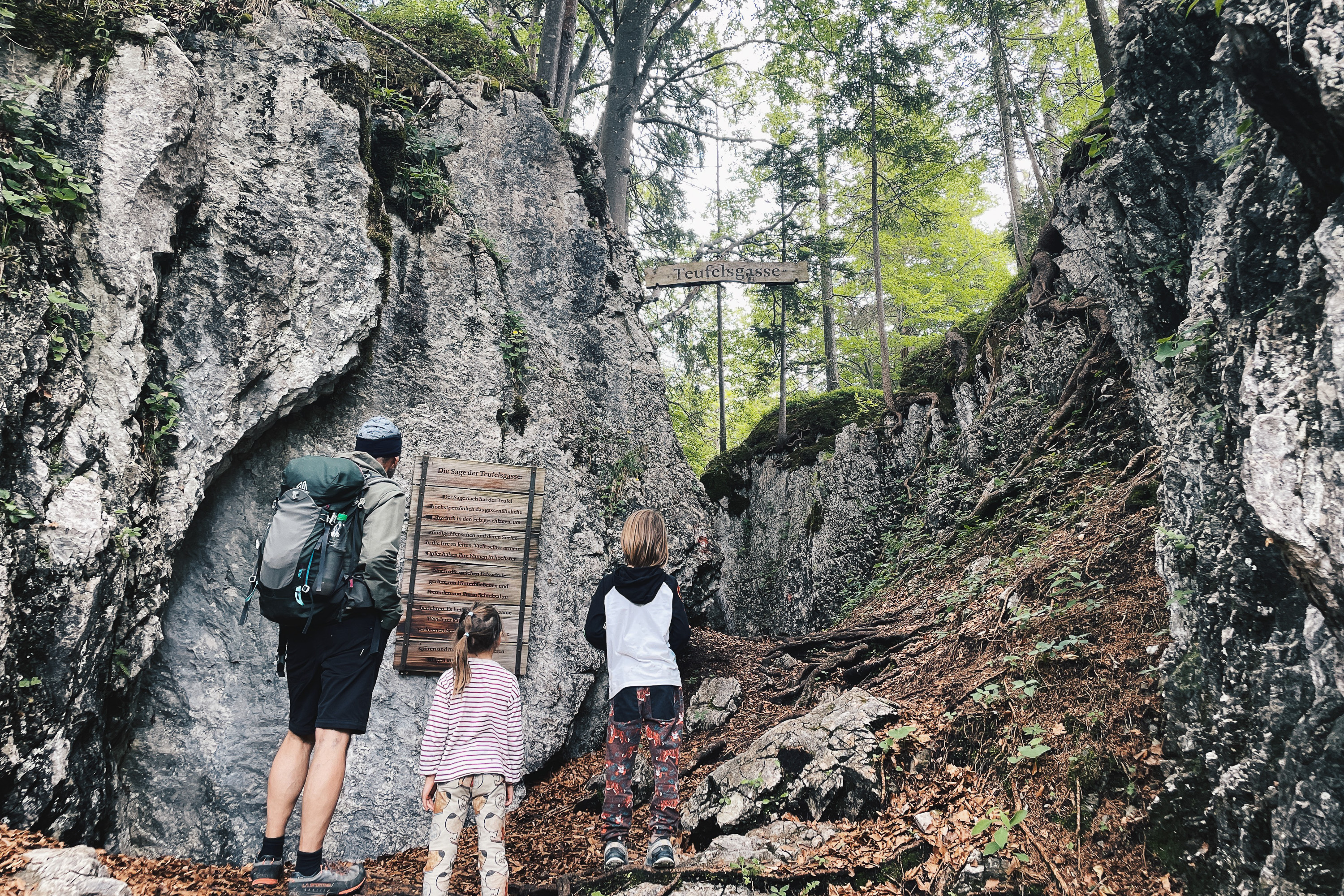 Familie beim Wandern durch das Felsenlabyrinth der Teufelsgasse