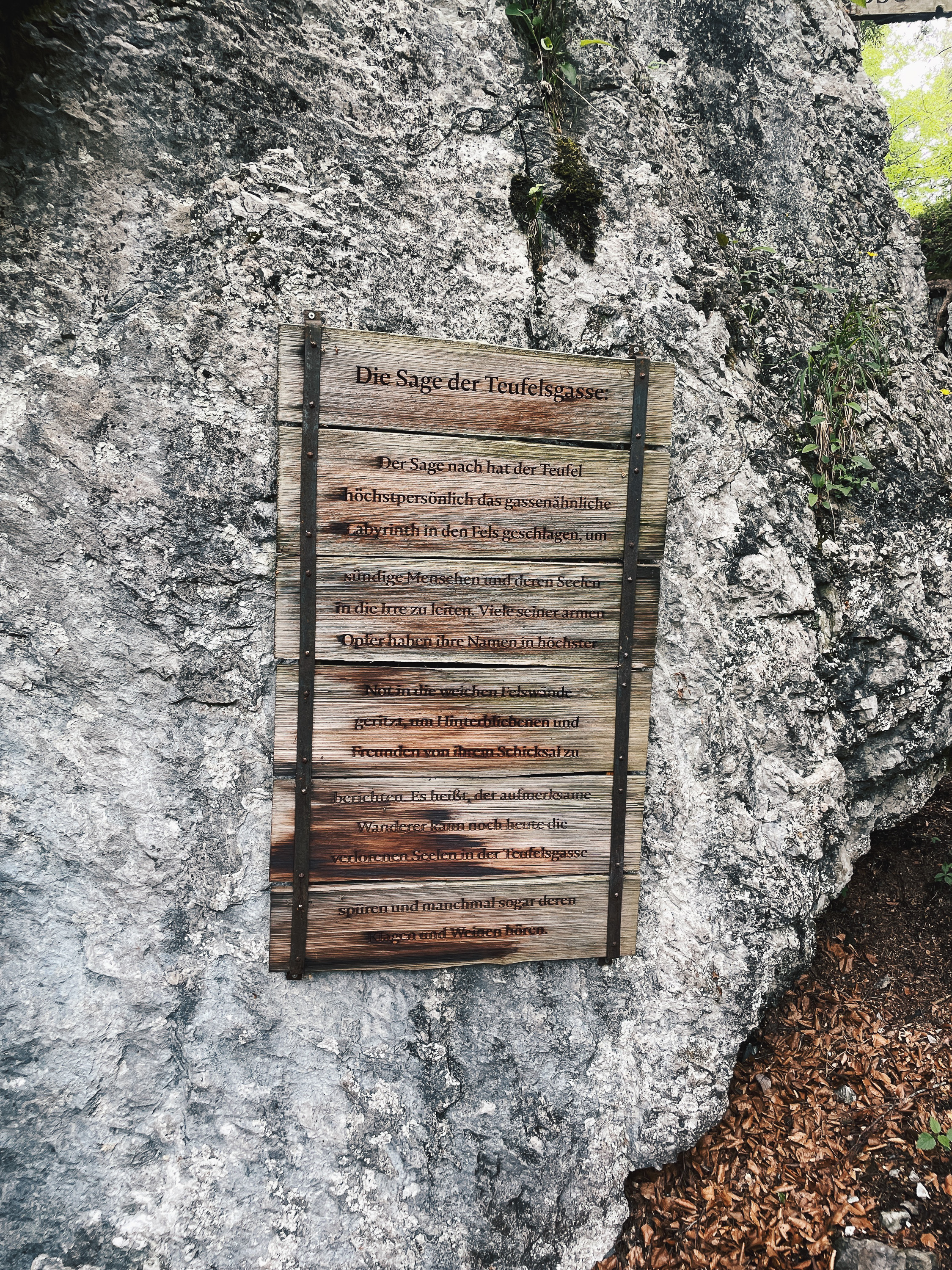 Hinweisschild zur Teufelsgasse zwischen den Felsen
